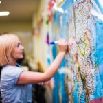 Student writing on world map