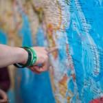 Student pointing to country on world map