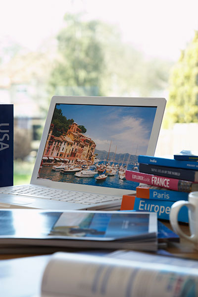 Laptop and travel books on desk
