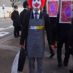 Student wearing Ronald McDonald mask and SUBWAY apron.