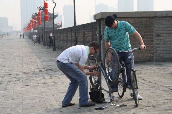 Man fixes bike in Xian, China.