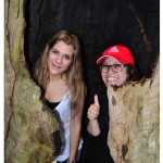 2 students inside a burnt out tree in the forest.