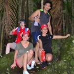 4 students on a rock in the rainforest