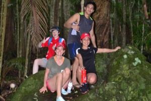 4 students on a rock in the rainforest