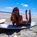 Melissa with surfboard at the beach