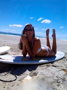 Melissa with surfboard at the beach