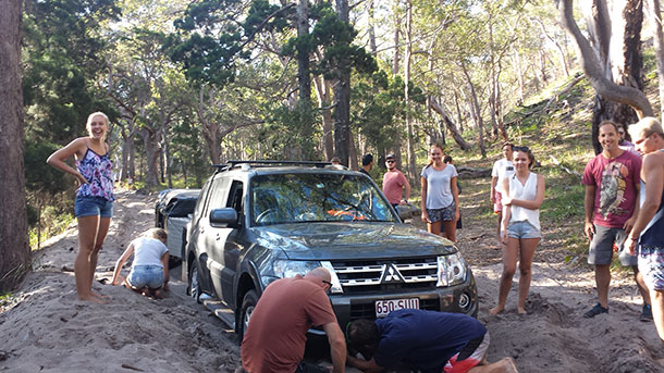4WD stuck in soft sand on Fraser Island - Ricky and friends stand by as strangers help dig them out.
