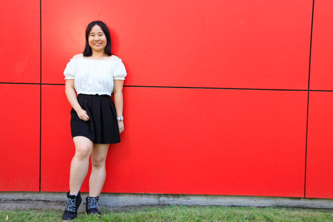 Anh infront of red wall