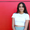 Aman Thind in front of a red wall