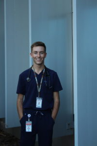 Ryan Churchill wearing medical scrubs facing camera. 