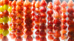 Stawberry fruits candy on stick coating with sugar caramel glaze. 
