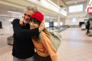 Father hugging daughter at the airport.