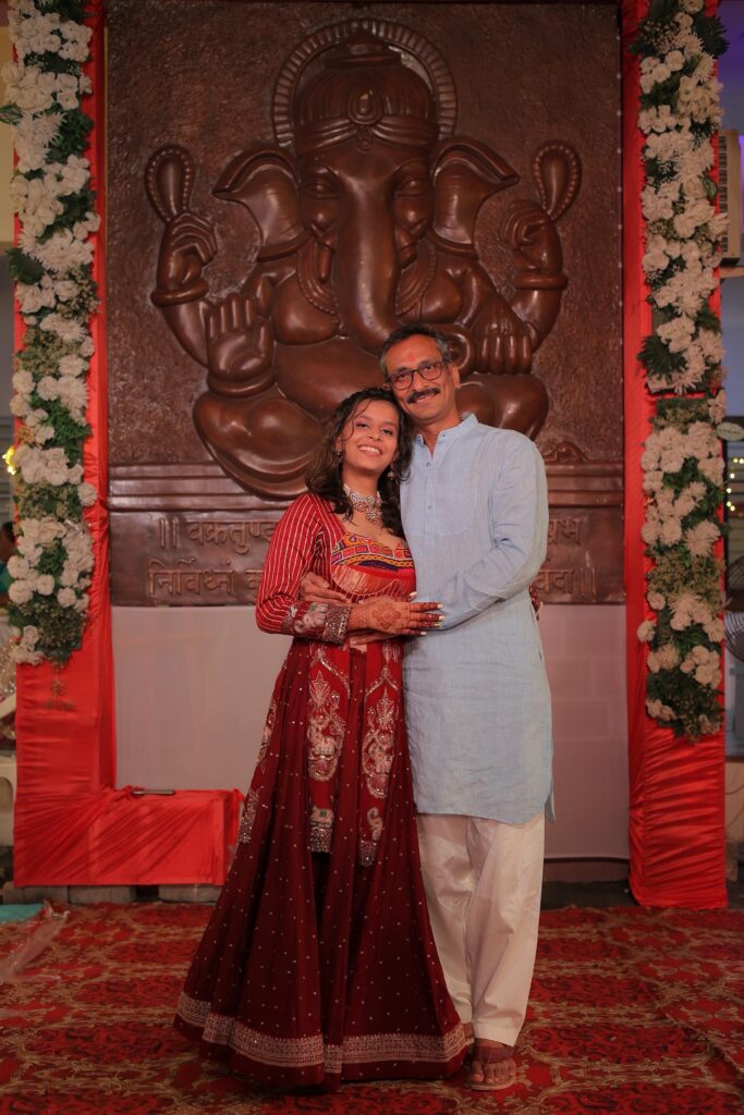 Griffith international student Netri standing with her father at a celebration in India.